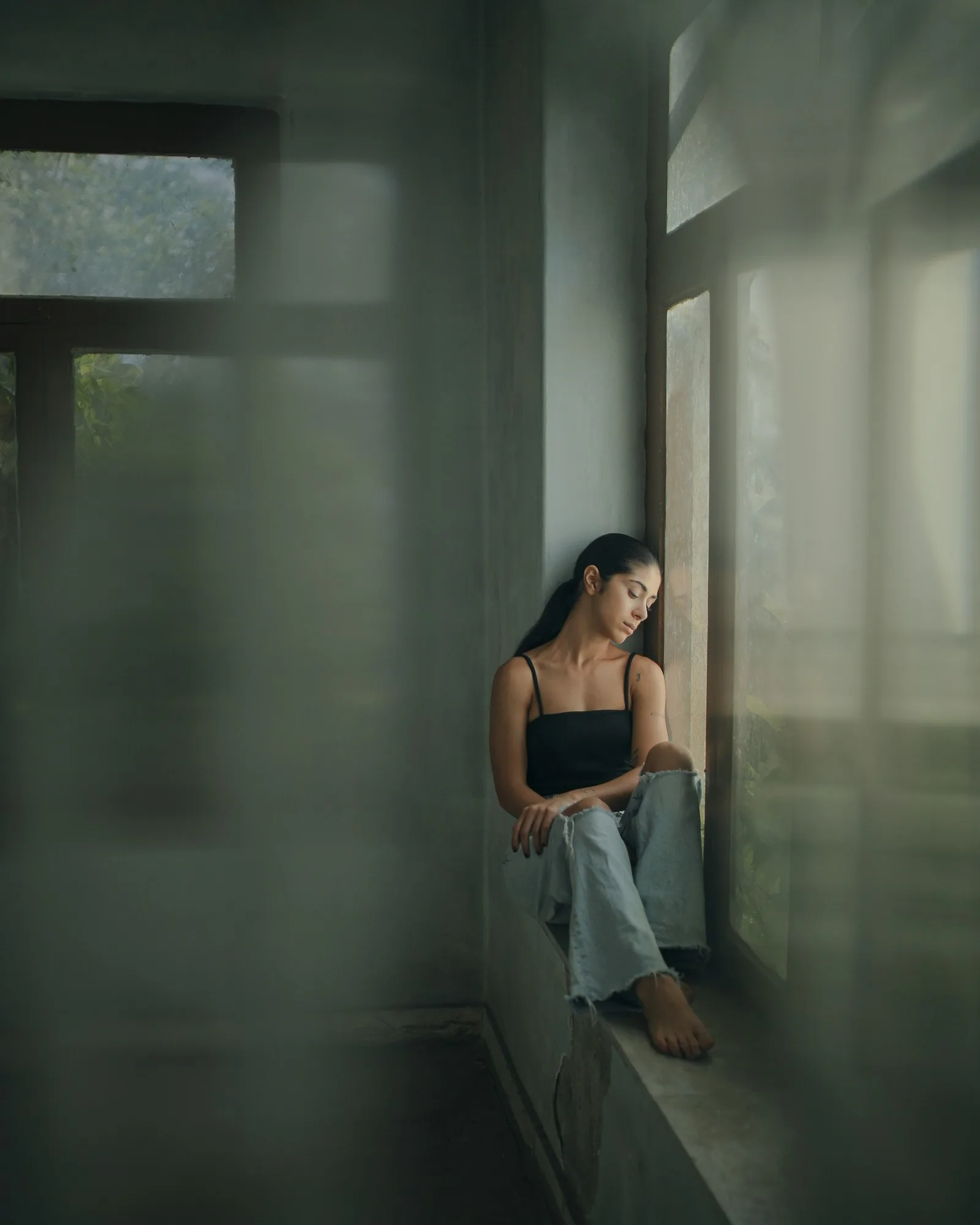 女子坐在窗邊望向戶外，呈現把恢復期交給安靜休息的日常